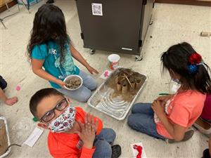 students smile and work together to create a shelter from the sun